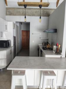 Una cocina con una gran mesa blanca y gabinetes blancos. en 26 Sandy Cove, en Hermanus 13 fotos más