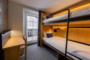 a room with two bunk beds and a window at Villars Lodge in Villars-sur-Ollon