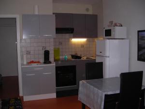cocina con electrodomésticos blancos y nevera blanca en Le Studio Sam, en Illkirch-Graffenstaden