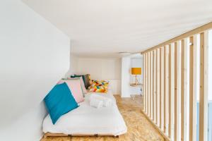 Habitación con cama con almohadas azules y blancas. en Le Pommeraye - Coeur de ville en Nantes