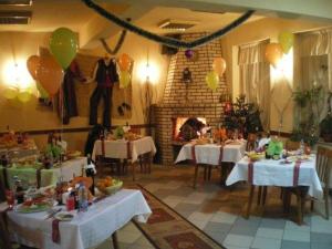 a dining room with tables and balloons and a fireplace at Edi Hotel in Zlatograd