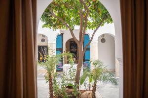 an archway with a tree in front of a building at Riyad El Cadi in Marrakesh