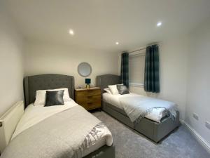 a bedroom with two beds and a mirror at The Hidden Nook in Whitby
