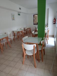 a dining room with tables and chairs and a green wall at Hotel Hawaii in Mar del Plata