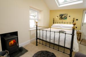 a bedroom with a bed and a wood stove at Anns Cottage, Chapel Stile in Chapel Stile +3 photos