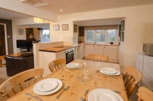 a kitchen and dining room with a wooden table and chairs at Langdale Hideaway in Chapel Stile