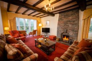 a living room with couches and a fireplace at Swallows House in Elterwater