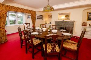 a dining room with a table and chairs and a fireplace at Swallows House in Elterwater
