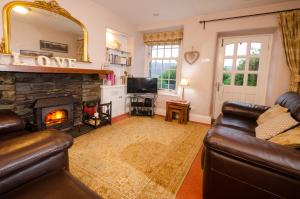 ein Wohnzimmer mit Couch und Kamin in der Unterkunft Valentine Cottage in Ambleside
