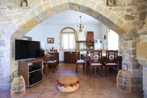 a kitchen and dining room with a stone wall at Villa Phaestias in Kalamaki Heraklion