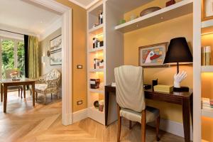 a home office with a desk and a dining room at Rocco Forte Hotel De Russie in Rome