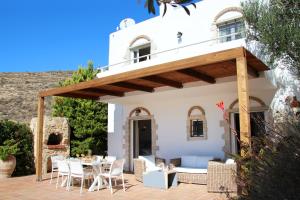 una casa y un patio con mesa y sillas en Villa Phaestias, en Kalamaki