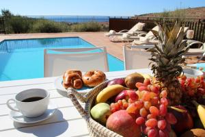 a table with a basket of fruit and a cup of coffee at Villa Phaestias in Kalamaki Heraklion