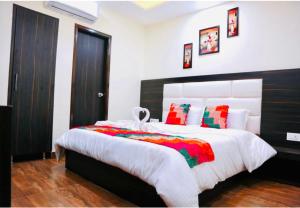 a bedroom with a large bed with red and green pillows at Hotel Kabir Residency in Amritsar