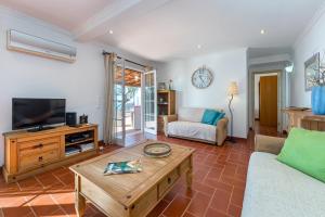 een woonkamer met een bank en een tv bij Casa Mimao in Albufeira