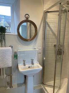 a bathroom with a sink and a shower at The Cross Keys Sherborne in Sherborne