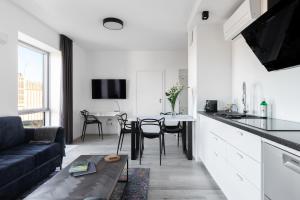 cocina y sala de estar con sofá y mesa en Stan Apartamenty Yacht Park Gdynia, en Gdynia