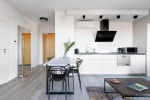 a kitchen and dining room with a table and chairs at Stan Apartamenty Yacht Park Gdynia in Gdynia