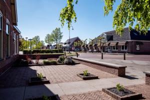 a brick courtyard in a town with buildings at B&B de Keinsmer in 't Zand