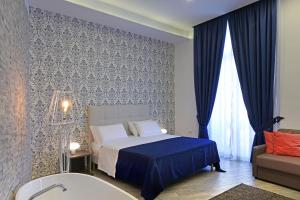 拿坡里的住宿－Barbarella HOTEL SPA，一间卧室配有一张床、一个浴缸和一张沙发