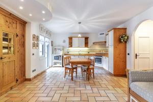 a kitchen with a wooden table and chairs at Valle Maura in Canazei
