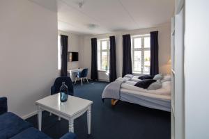 a living room with a bed and a table at Skagen Hotel in Skagen