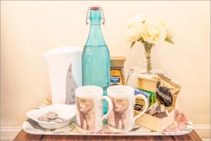 a tray with a bottle and mugs on a table at La Vieille Distillerie in Matha