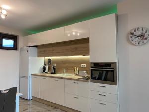 una cucina bianca con lavello e frigorifero di Breathtaking sea view apartment a Varna