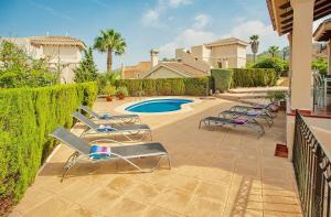 a patio with lounge chairs and a swimming pool at 3 Bed House - Sleeps 6 - Pool - Garden - Parking in Atamaría