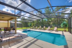 uma piscina com um telhado de vidro sobre ela em South Facing Pool Near Disney 5 Bed Luxury em Kissimmee