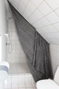 a shower curtain in a bathroom with a toilet at Skråvej Bed & Breakfast in Skagen