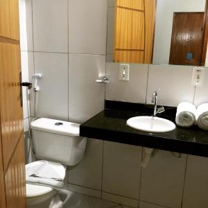 a bathroom with a toilet and a sink at Abolição Praia Hotel in Fortaleza
