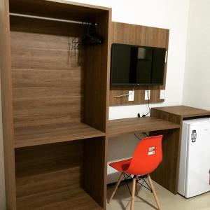 a room with a desk and a tv and a red chair at Abolição Praia Hotel in Fortaleza +31 photos