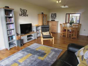 ein Wohnzimmer mit einem Sofa, einem TV und einem Tisch in der Unterkunft Owl Barn Sisland - spacious apartment in Norwich
