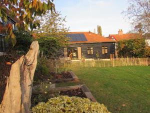 a house with a fence and a garden in front of it at Owl Barn Sisland - spacious apartment in Norwich