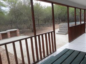 a screened in porch with a green bench on it at Wild Escape in Marloth Park