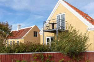 a yellow house with a red fence at Foldens Hotel Annex in Skagen