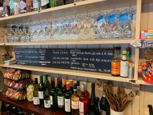 un estante lleno de botellas de vino y vasos en The Compasses, en Chelmsford