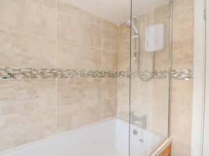 Un baño con ducha y bañera. en Sea Otter Cottage, en Appin 25 fotos más