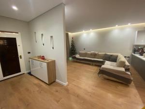 a living room with a couch and a christmas tree at Villa Panorama - 3 Bedrooms Sea View - Free Parking in Sarandë +12 photos