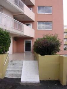 un edificio con escaleras y plantas delante de él en Appartement Cap D'Agde, en Cap d'Agde