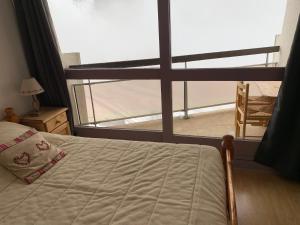 a bedroom with a bed and a large window at La Moucherolle in Villard-de-Lans