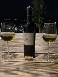 a bottle of wine and two glasses on a table at Villa Panorama - 3 Bedrooms Sea View - Free Parking in Sarandë