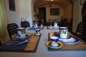 un tavolo con tazze e piattini blu e bianchi di La Torretta Bianca a Cava deʼ Tirreni