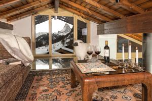 - un salon avec une table et des verres de vin dans l'établissement Penthouse Zen Zermatt, 100m from Ski Lift and Piste, à Zermatt