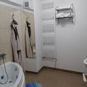 a bathroom with a tub and a toilet and a sink at Karla Residence / Greta Residence in Reşiţa +31 photos