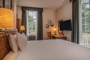 a hotel room with a large bed and a television at De Vere Beaumont Estate in Windsor