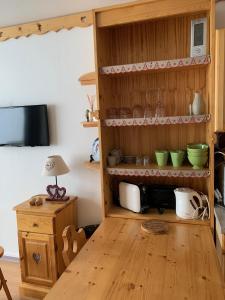 a kitchen with wooden shelves and a table at La Moucherolle in Villard-de-Lans