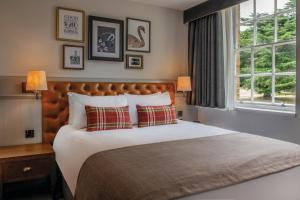 um quarto com uma cama grande e uma janela em De Vere Beaumont Estate em Windsor