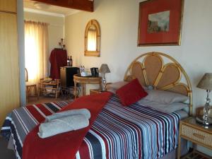 a bedroom with a large bed with a striped blanket at Seesterkloof in Stilbaai